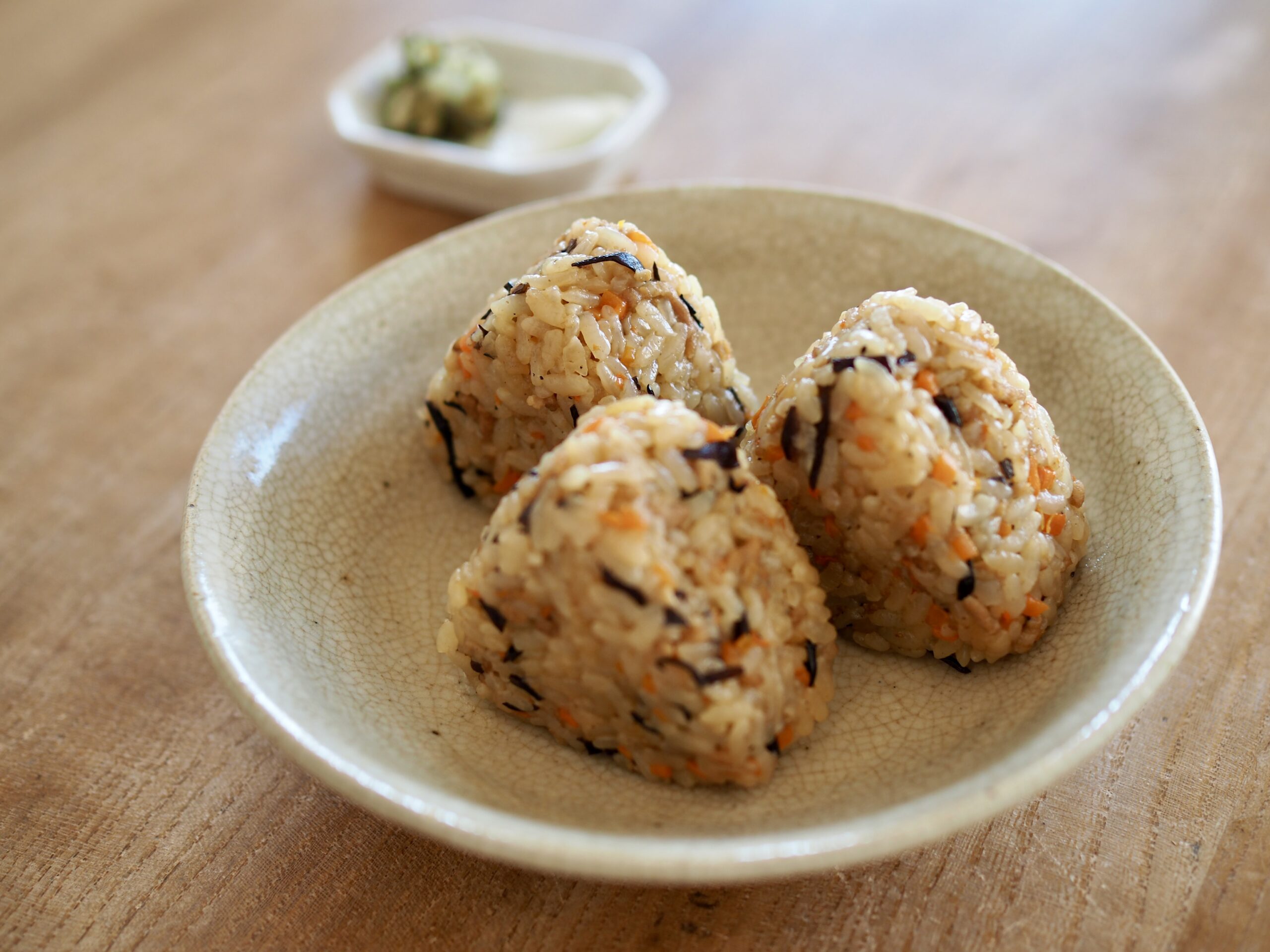 子どもが野菜を味わっている様子。シンプルな食事の写真。笑顔で楽しむ食卓。