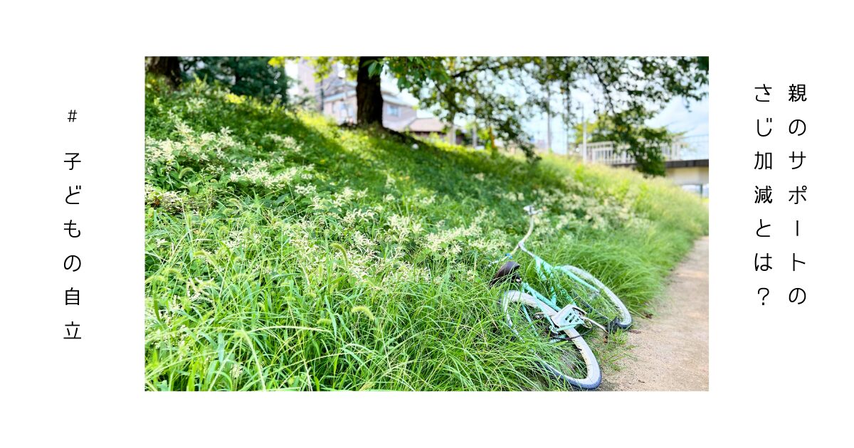 後ろから支え、見守る親と、自転車に乗る子供